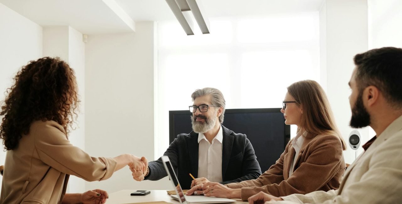 Business meeting with freelancers. Boss shaking hands with a freelancer in a modern office