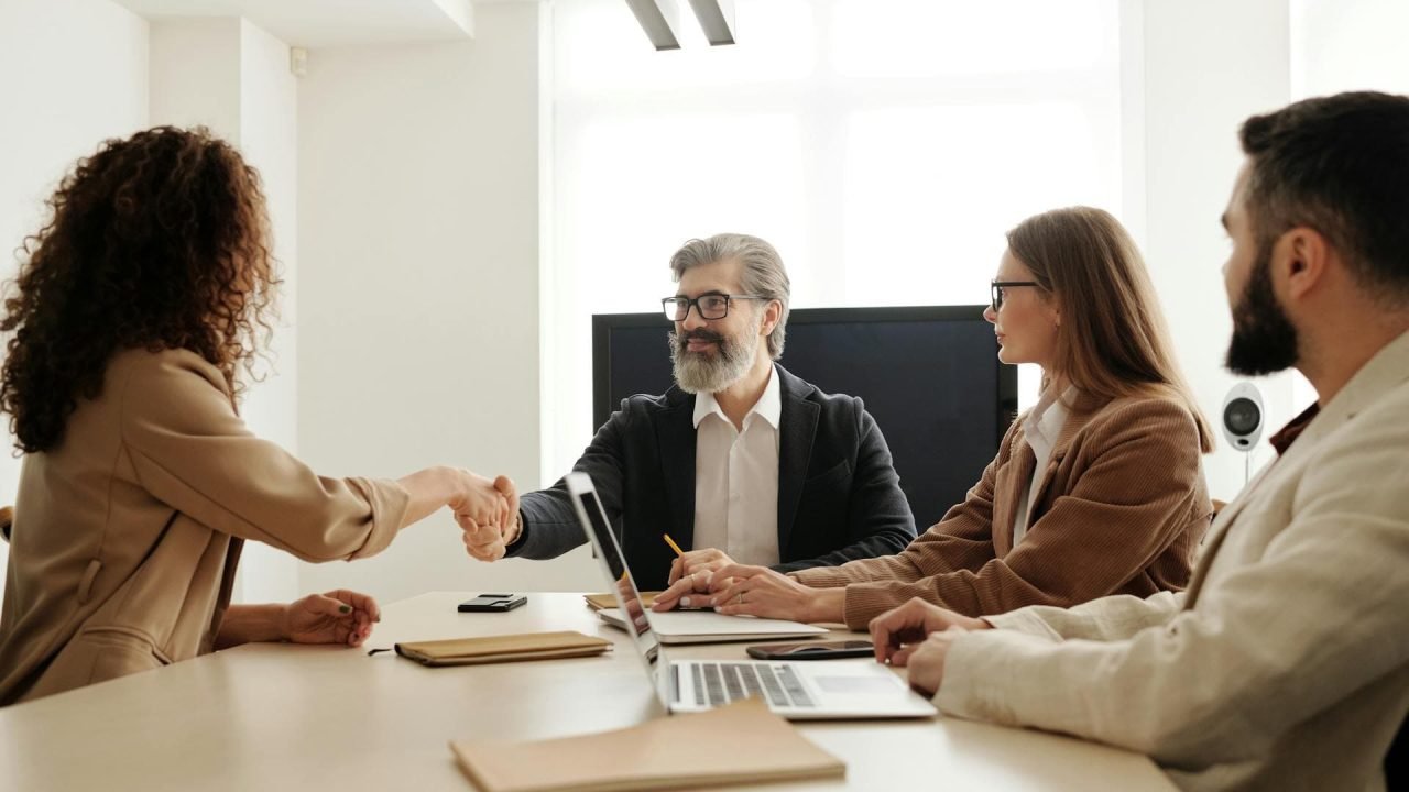 Business meeting with freelancers. Boss shaking hands with a freelancer in a modern office