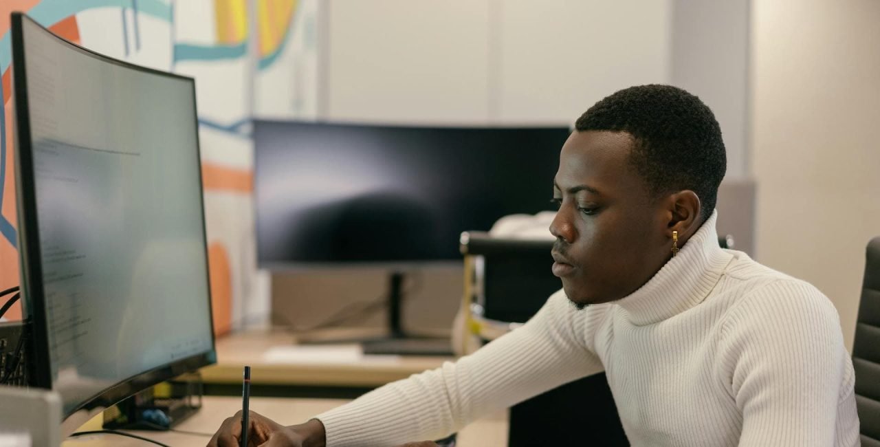 Freelancer working on a laptop at a desk in a professional setting.