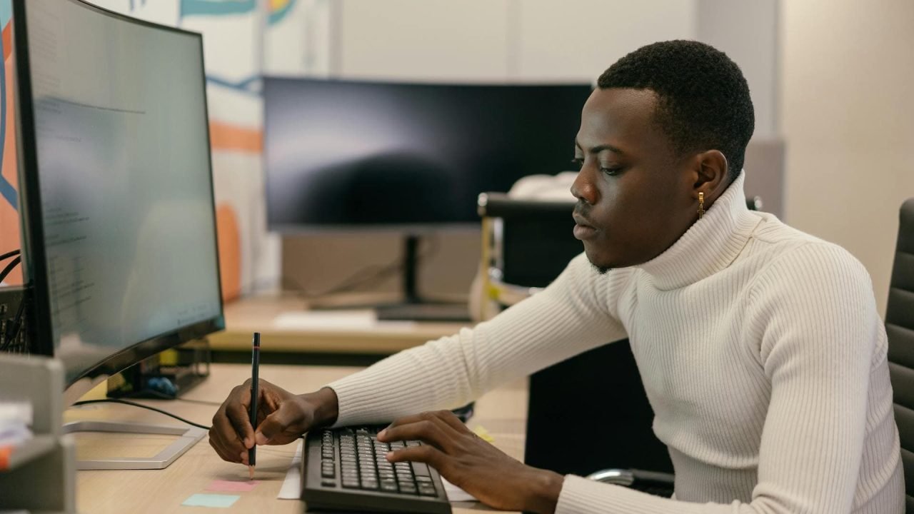 Freelancer working on a laptop at a desk in a professional setting.