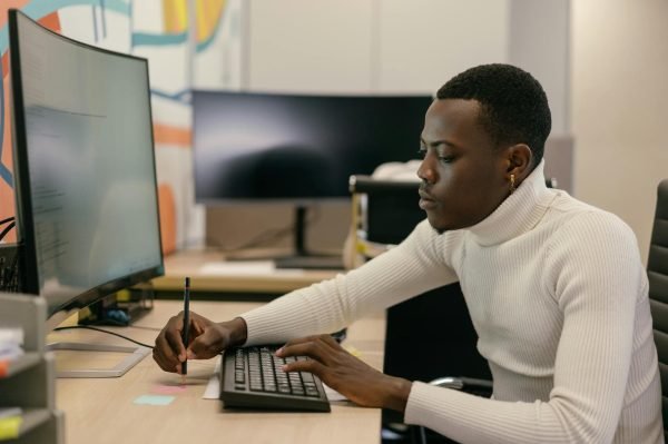 Freelancer working on a laptop at a desk in a professional setting.