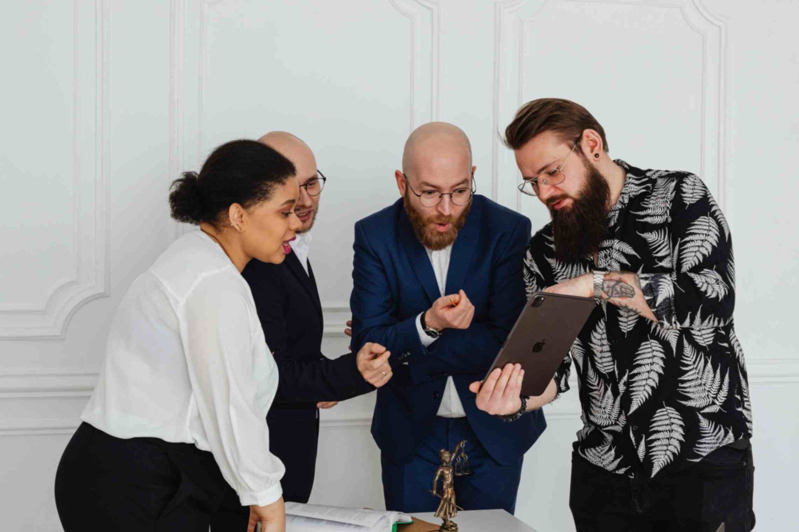 People in the Office Looking at the Ipad While Having a Discussion